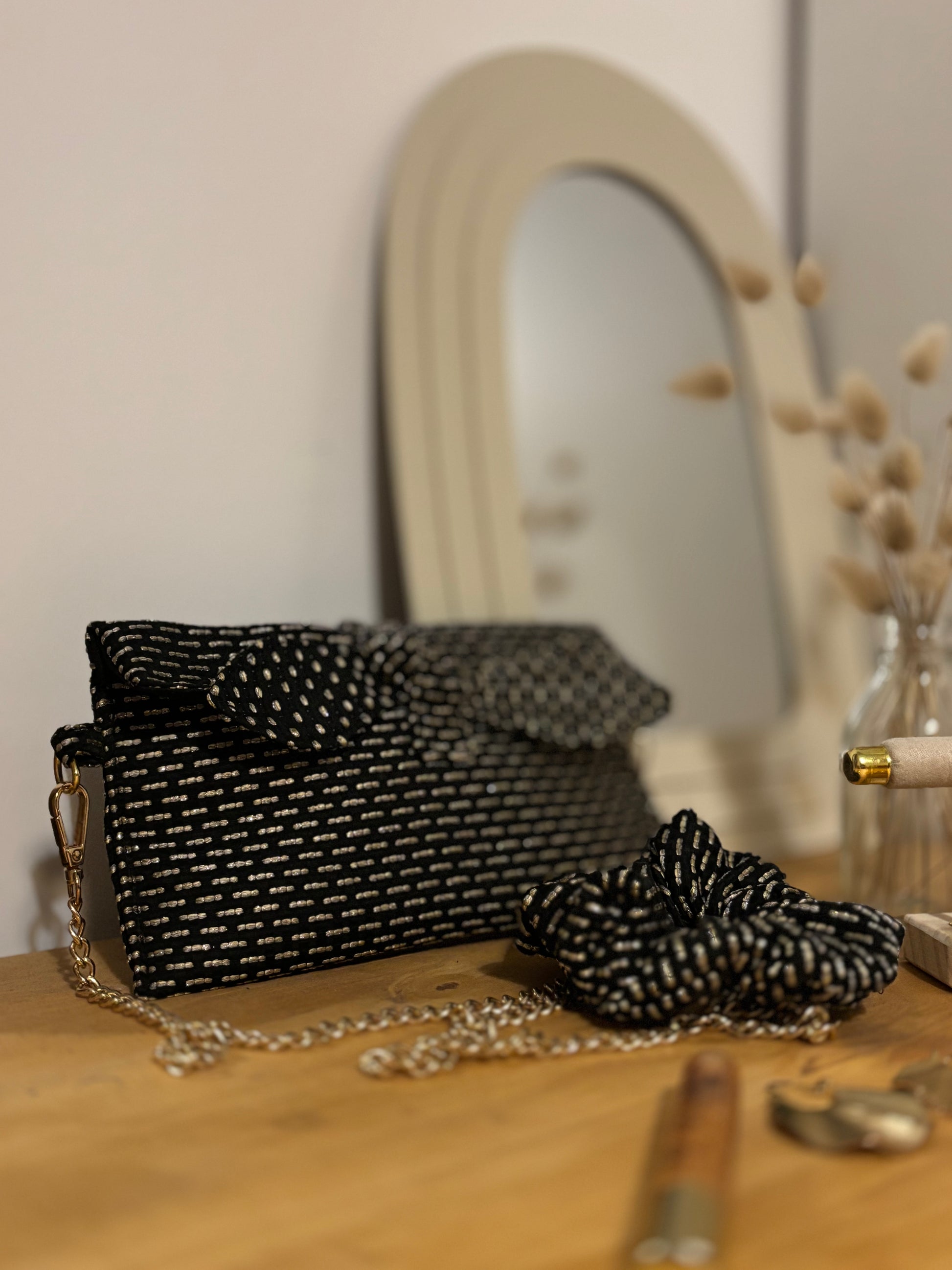 Trousse noire Alma de SueGiu posée à plat, avec sa forme rectangulaire et ses détails sobres et élégants. Tissu texturé noir profond, fermeture éclair dorée, ambiance minimaliste et chic.