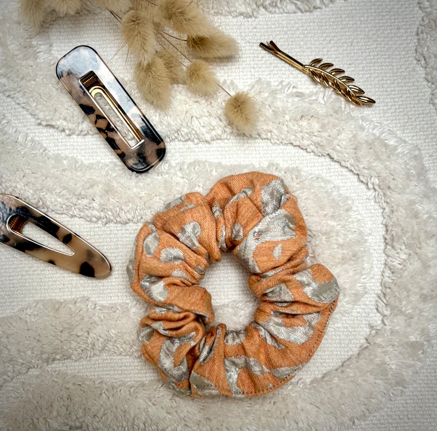 Chouchou bijou Bohémia en tissu texturé avec détails argents, accessoire élégant et pratique pour cheveux ou poignet.