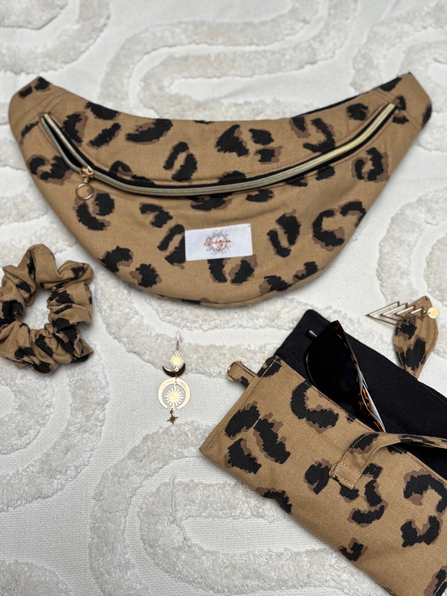 Banane beige léopard, symbole de liberté et de style au quotidien. Ce modèle allie audace et douceur, parfait pour garder les mains libres avec élégance. Confectionnée à la main avec un tissu jacquard de qualité, elle ne se déforme pas et conserve sa tenue. Idéale pour accompagner les journées actives avec une touche de féminité bohème.