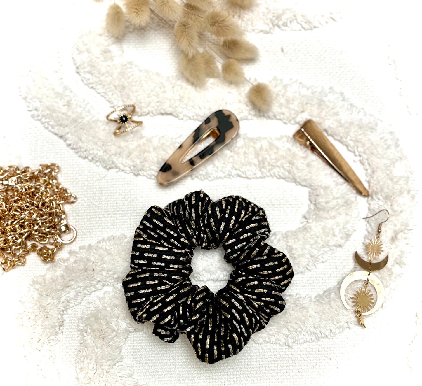 Chouchou bijou Bohémia en tissu texturé avec détails dorés, accessoire élégant et pratique pour cheveux ou poignet.