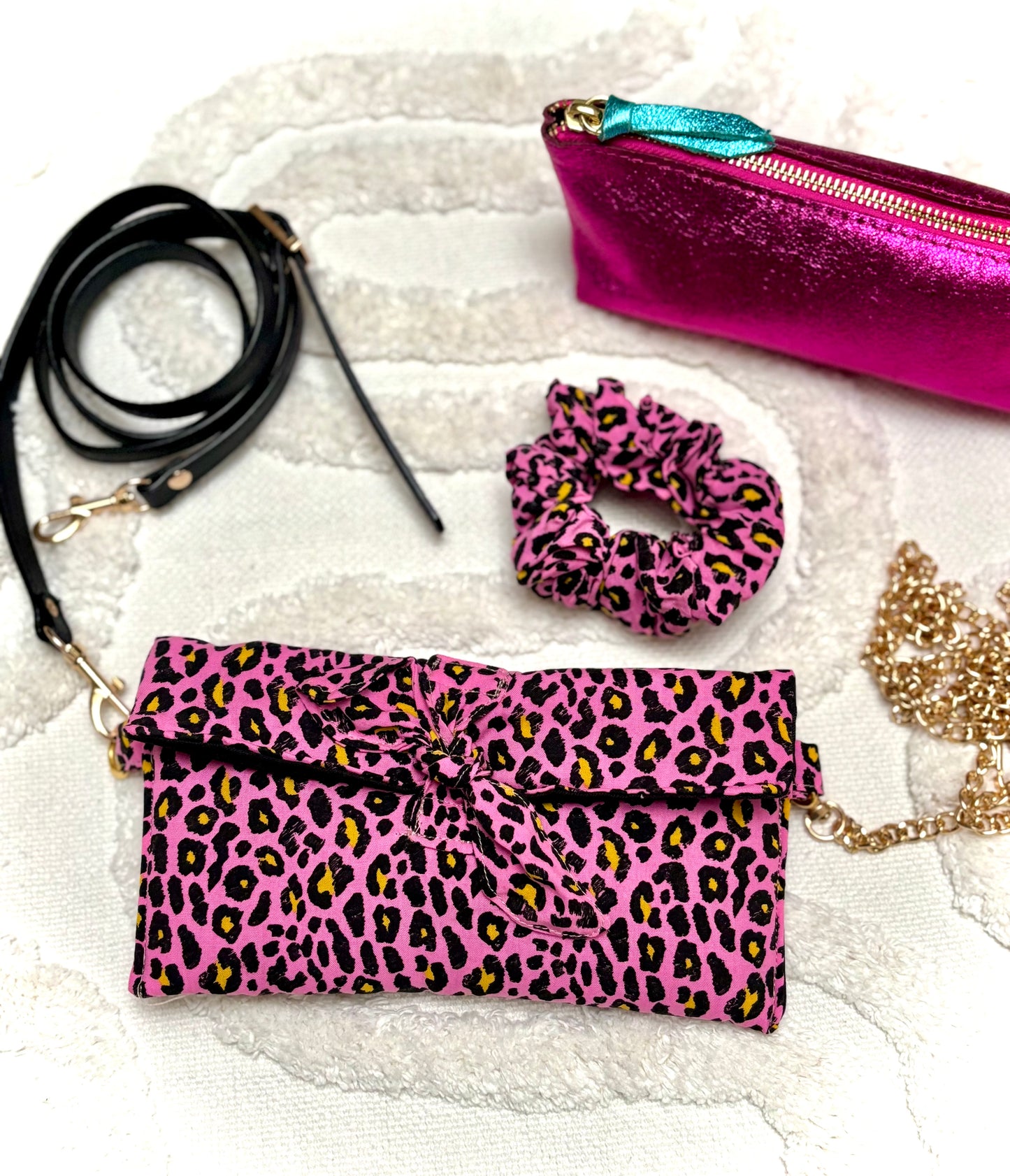 Trousse et chouchou assortis en tissu léopard rose de la collection Bohémia par SueGiu, chaîne dorée et trousse et sangle noire , dans une ambiance féminine, tendance et pratique.