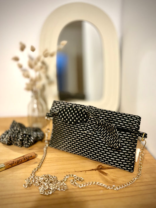 Trousse noire Alma de SueGiu posée à plat, avec sa forme rectangulaire et ses détails sobres et élégants. Tissu texturé noir profond, fermeture éclair dorée, ambiance minimaliste et chic.