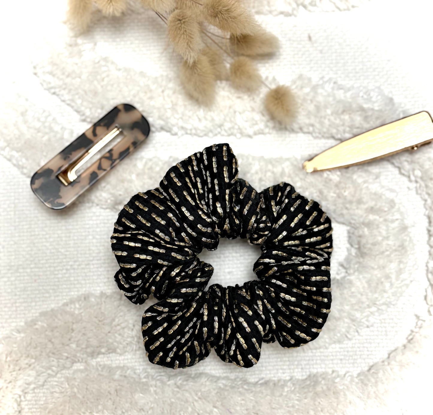Chouchou bijou Bohémia en tissu texturé avec détails dorés, accessoire élégant et pratique pour cheveux ou poignet.
